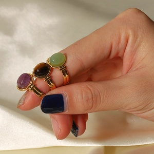 18K gold-plated oval gemstone rings with tiger eye and purple stones on silk background