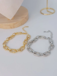 Detalle de las pulseras de eslabones entrelazados en oro y plata con engaste de pavé