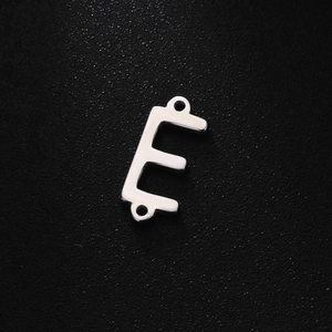 Close-up of silver stainless steel letter E charm with dual holes for DIY jewelry