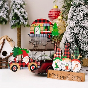 Three festive wooden gnome signs with Merry Christmas text on a holiday table setting