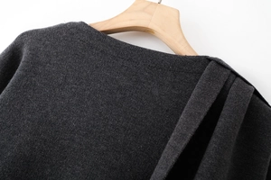 Detailed view of dark grey knitted shawl with elegant shoulder pleated drape texture