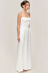 Close-up of white satin evening dress featuring delicate straps and V-shaped waist seam
