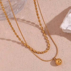 Detail of 18K gold plated double layer necklace with oval beads and spherical pendant