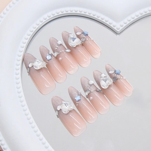 Cat eye gradient press-on nails with heart rhinestones and star charms on mirror tray