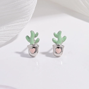 Macro shot of silver cactus stud earrings with green enamel and pink heart pot detail