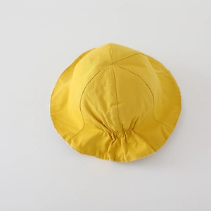 Détail du chapeau de soleil en coton jaune avec coutures à six pans et dos élastique