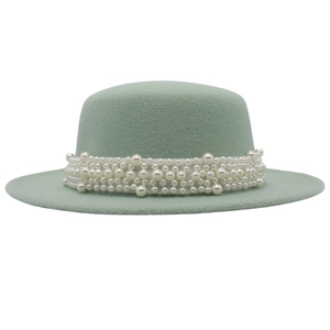 Detail of elegant mint green wool felt hat featuring stylish multi-layer white pearl chains