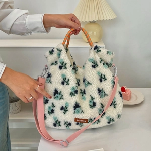 Close-up of floral lamb wool tote bag showing braided handles and pink shoulder strap