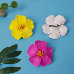 Three colorful 10cm hibiscus flower hair clips in pink white and yellow on blue background