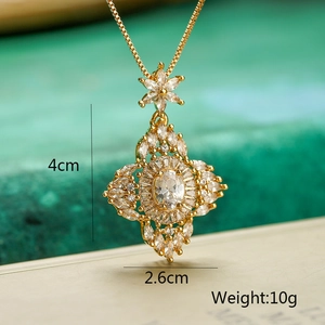 Close-up of gold flower pendant with zircons and size dimensions 4cm by 2.6cm