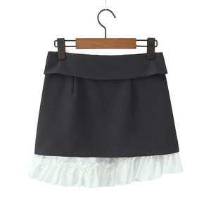Detailweergave van rok met hoge taille van zwarte stof en witte ruches aan de zoom