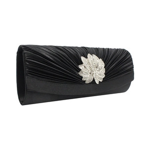Close-up of black pleated satin evening clutch with sparkling crystal floral clasp detail