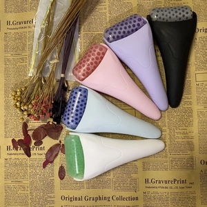 Detailed view of six colorful ice rollers for facial skincare on vintage newspaper