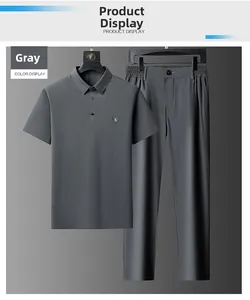 Detail view of men's grey ice silk polo shirt and trousers with shield chest badge