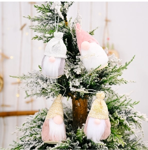 Nahaufnahme von vier gestrickten Wichteln mit Kunstfellbart an einem verschneiten Baum