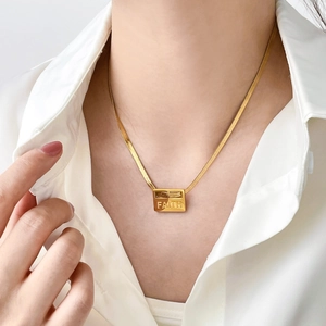 Golden Faith rectangle pendant necklace with snake chain worn on a white shirt