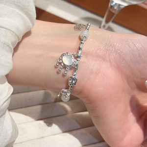 Detail of S925 silver bracelet with Fu character charm and white moonstone pendant