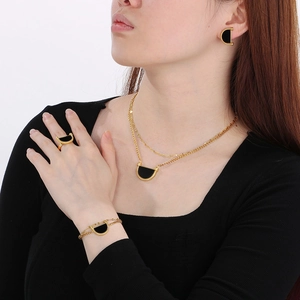 Detailed set of gold titanium jewelry with black semi-circle inlays and bead accents
