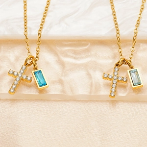 Detailed shot of golden cross necklace with shimmering zircon and blue gemstone pendant