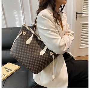 Detail of vintage large tote bag with brown dot pattern and cream handles on a model