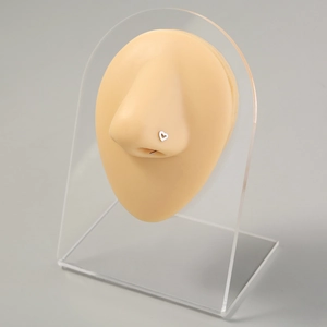 Silver heart-shaped stainless steel nose ring displayed on a clear acrylic stand