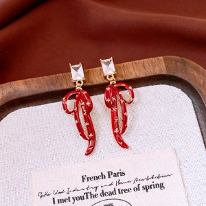 Close-up of vintage French bow earrings with red enamel and sparkling zircon detail