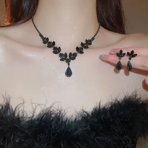 Elegant black teardrop jewelry set with wheat ear motif necklace and earrings on model