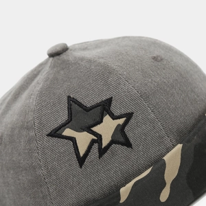 Macro shot of embroidered stars with camouflage pattern on gray cotton beanie cap