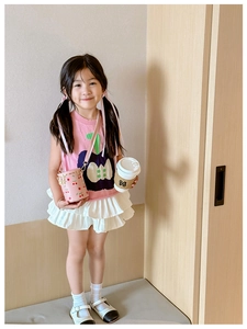 Pink cherry bucket bag shown with a girl outfit and stylish wooden interior decor