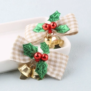 Detailed view of checkered Christmas bows with green leaves, red berries and gold bells