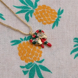 Christmas necklace with heart shaped candy canes pendant and a gold bow tie design