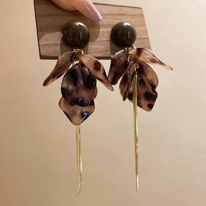 Gros plan des boucles d'oreilles vintage en résine léopard avec pampilles dorées