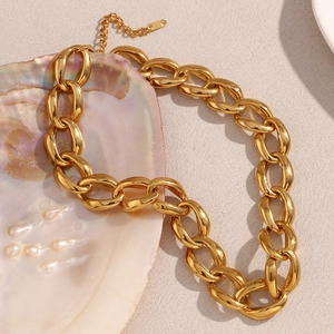 Macro detail of the 18K gold plated chunky chain necklace on a pearl shell