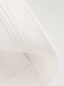 Macro shot of double parallel stitching on white high-density cotton fabric edge