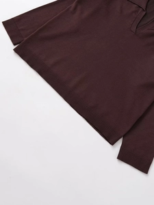 Detail of dark chocolate knit polo shirt featuring ribbed cuffs and fine fabric texture