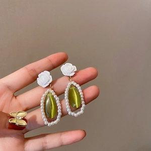 Detail of rose stud earrings with green opal pendant and white pearl inlay