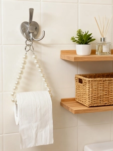 Macro detail of elegant cream faux pearl bead roll paper holder with silver metal hanging ring