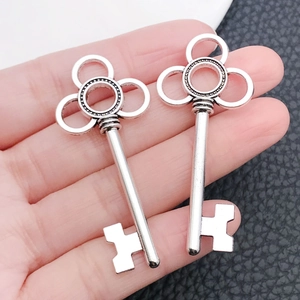 Close-up of vintage silver skeleton key pendants with intricate clover leaf heart cutouts