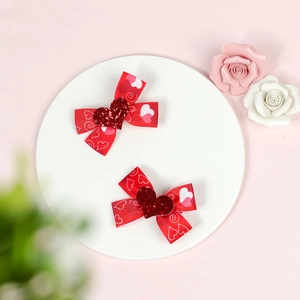 Set of two red ribbon hair clips with glittery hearts and white heart patterns