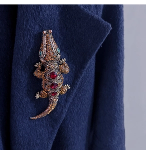Detail der Vintage-Krokodilbrosche mit Bernsteinkristallen und roten Edelsteinen