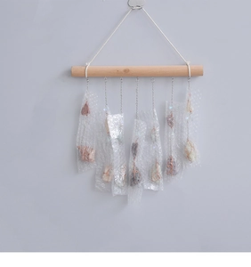 Detailed view of raw crystal stones hanging from a wooden bar for dreamcatcher decor