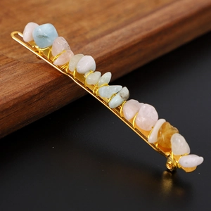 Macro shot of colorful natural crystal stones wire-wrapped on a golden metal hair pin