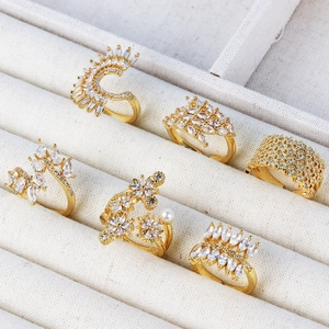 Set of gold-plated rings with white zircon and pearls on a premium jewelry stand
