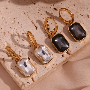 Detailed shot of 18K gold plated rectangular zircon earrings in white and smokey grey