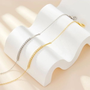 Minimalist S925 silver and gold cubic zirconia bracelets on a white wave display stand