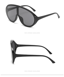 Detail view of oversized black wrap-around shield sunglasses with sleek Y2K futuristic design