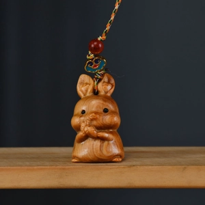 Details eines handgefertigten Thuja-Holzhasen-Anhängers mit bunter Kordel und Perlen