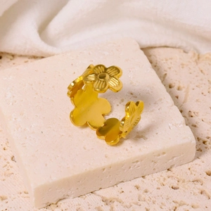 Adjustable gold flower open ring in stainless steel on a minimalist stone base
