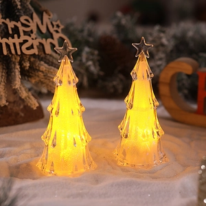 Detail showing two acrylic Christmas tree night lights with warm glow and star topper