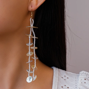 Long beaded tassel earrings featuring iridescent shell discs and gold fishhook wires